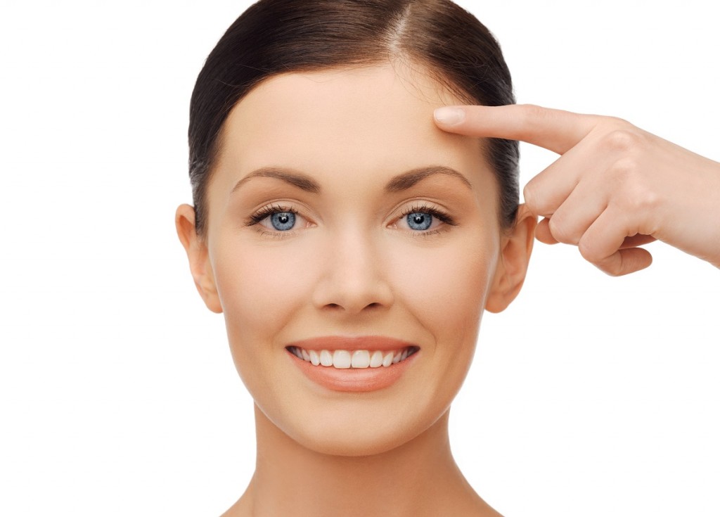 anti-aging concept - beautiful woman pointing to forehead