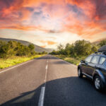 Strešný box upevnený na aute počas jazdy po diaľnici, kde vzniká aerodynamický hluk.