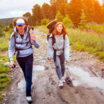 Turista kráča opatrne po mokrom a klzkom horskom chodníku