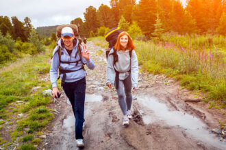 Turista kráča opatrne po mokrom a klzkom horskom chodníku