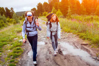 Turista kráča opatrne po mokrom a klzkom horskom chodníku